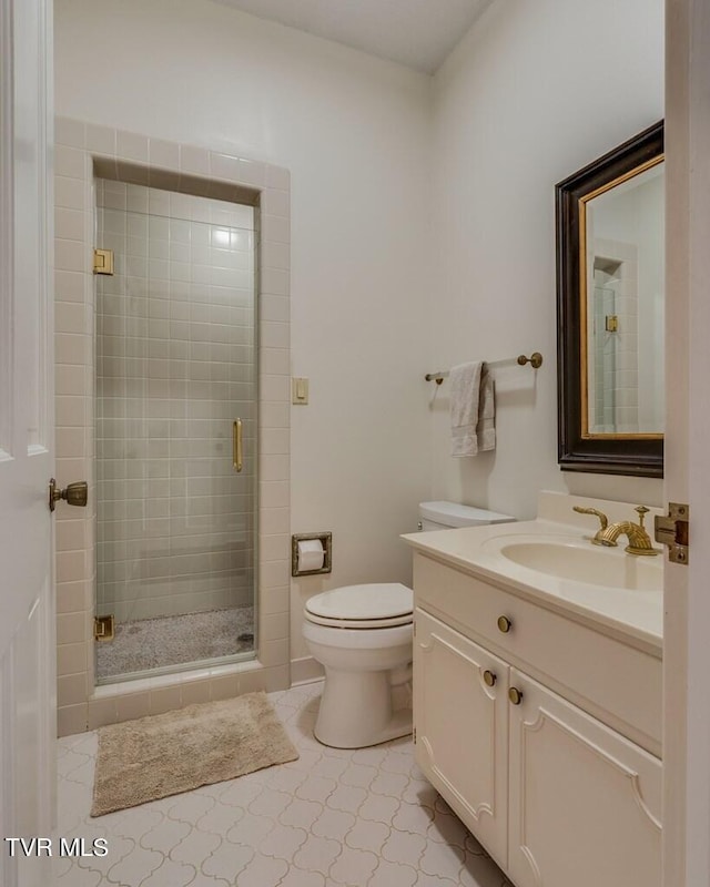 bathroom featuring tile patterned floors, vanity, a shower with door, and toilet