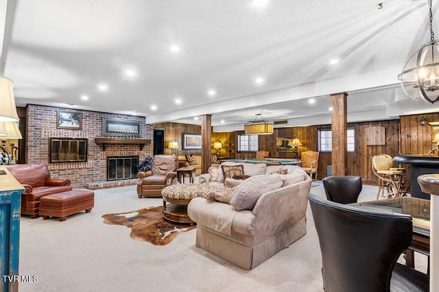 living room featuring brick wall, carpet, a fireplace, and wooden walls