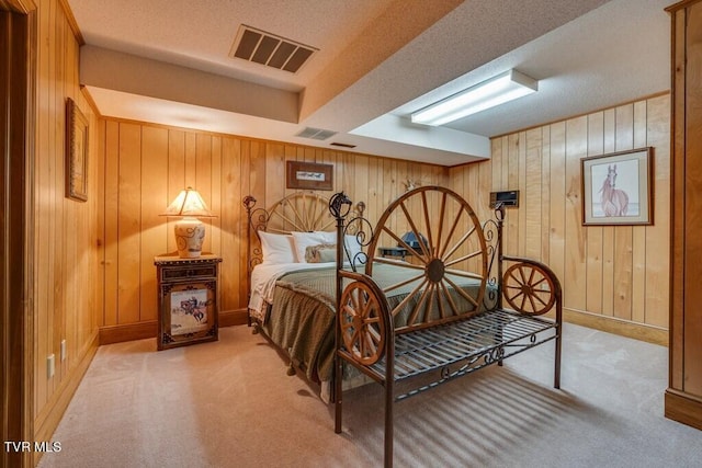 carpeted bedroom with wood walls, a closet, and a textured ceiling