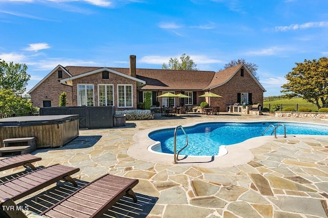 view of swimming pool with a patio and a hot tub