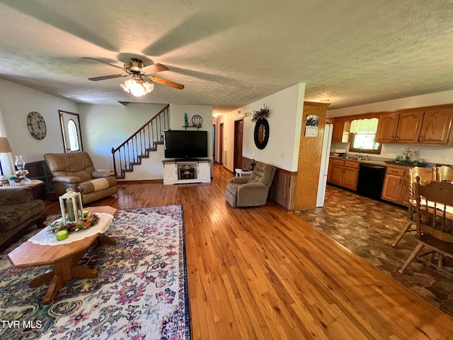 living room with dark hardwood / wood-style floors, sink, ceiling fan, and a textured ceiling