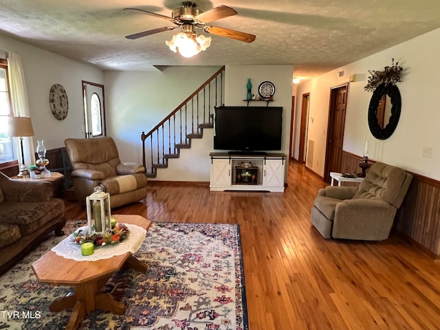 living room featuring a textured ceiling, ceiling fan, and hardwood / wood-style floors