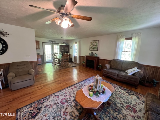 living room featuring hardwood / wood-style flooring, plenty of natural light, ceiling fan, and a textured ceiling