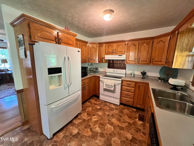 kitchen featuring sink, white appliances, dark hardwood / wood-style floors, and a textured ceiling