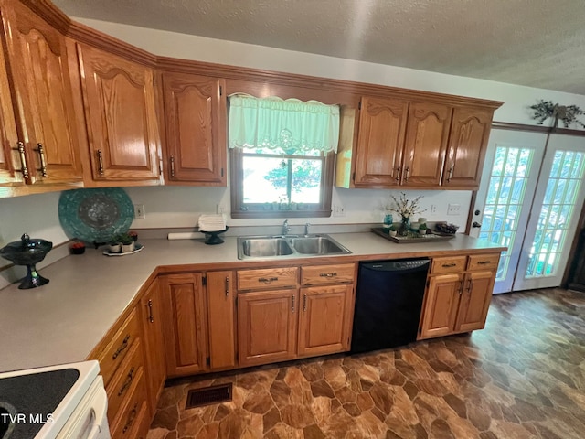 kitchen featuring dishwasher, stove, a textured ceiling, dark tile flooring, and sink