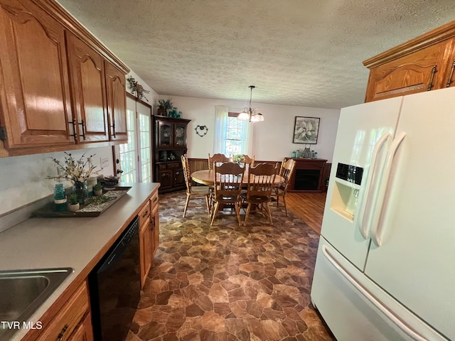 kitchen with black dishwasher, pendant lighting, dark tile floors, white refrigerator with ice dispenser, and a chandelier