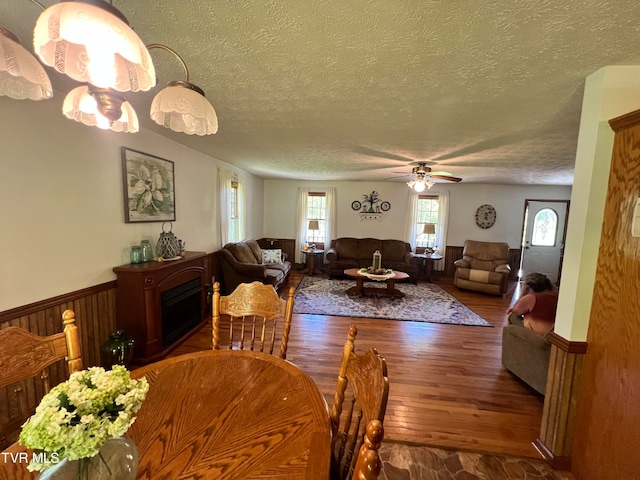 dining room with a textured ceiling, hardwood / wood-style floors, and ceiling fan