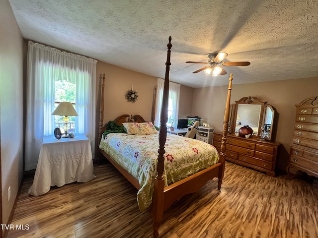 bedroom with wood-type flooring, ceiling fan, and a textured ceiling