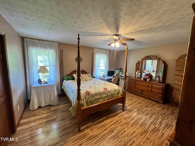 bedroom featuring wood-type flooring, ceiling fan, and a textured ceiling