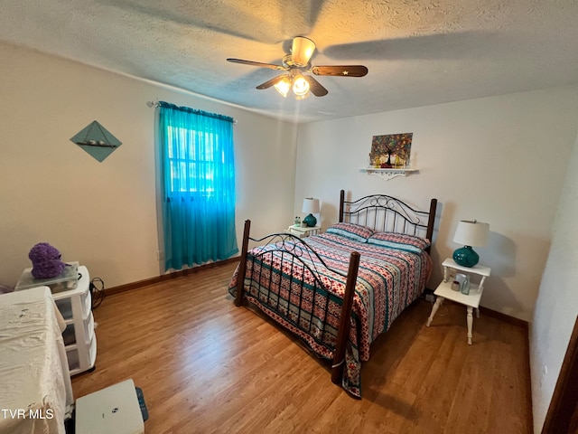 bedroom featuring hardwood / wood-style floors, ceiling fan, and a textured ceiling