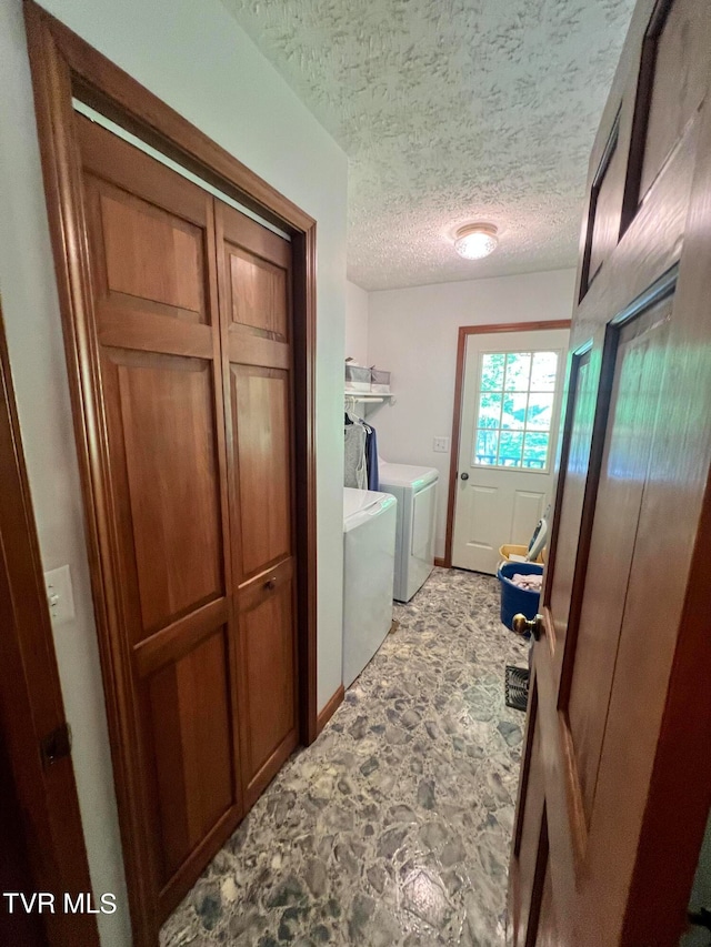 bathroom featuring washing machine and dryer, a textured ceiling, and tile flooring