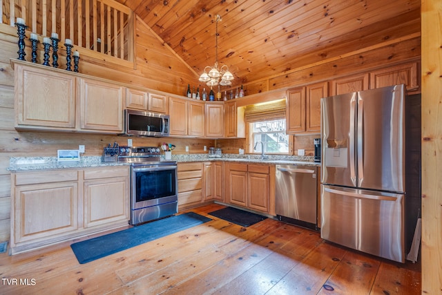 kitchen with high vaulted ceiling, stainless steel appliances, light stone counters, and wood-type flooring