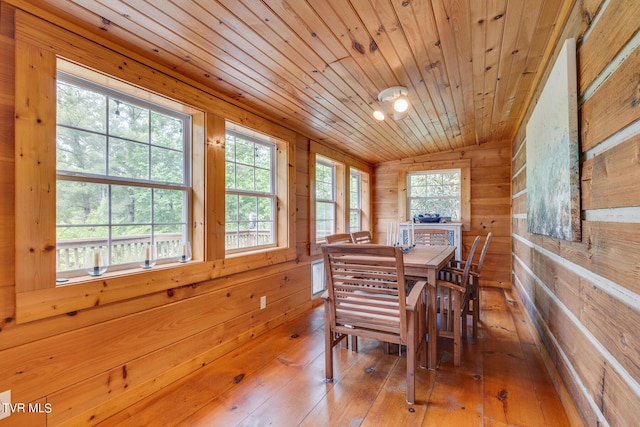 dining area with wood walls, hardwood / wood-style floors, wood ceiling, and lofted ceiling