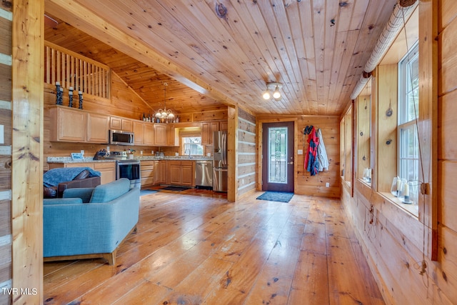 living room with vaulted ceiling, light wood-type flooring, wood ceiling, sink, and wooden walls