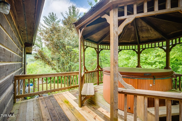 wooden terrace featuring a gazebo and a hot tub