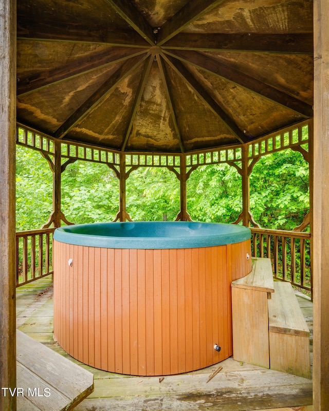 view of terrace with a hot tub and a gazebo