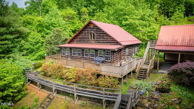 rear view of property featuring a wooden deck