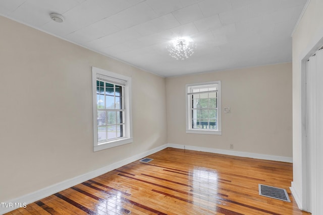 spare room featuring wood-type flooring and plenty of natural light