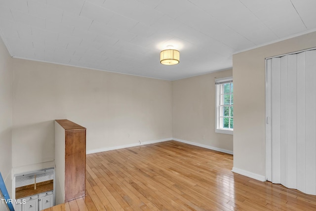 unfurnished bedroom with ornamental molding, light hardwood / wood-style floors, and a closet