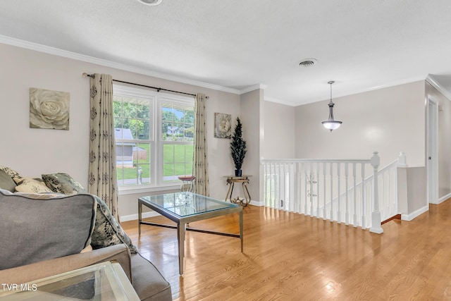 living room with crown molding and light hardwood / wood-style flooring