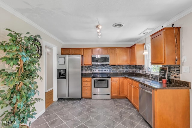 kitchen with tile flooring, decorative light fixtures, rail lighting, sink, and appliances with stainless steel finishes