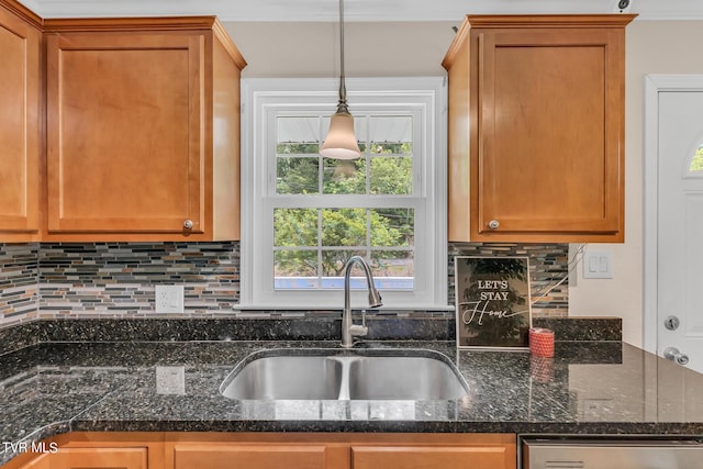 kitchen with a healthy amount of sunlight, sink, dark stone counters, and tasteful backsplash