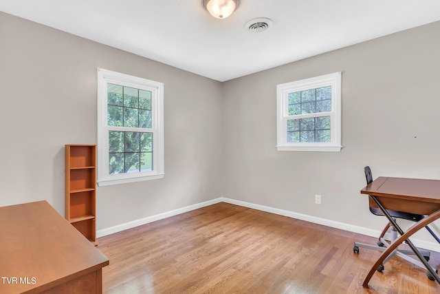 office with plenty of natural light and light wood-type flooring