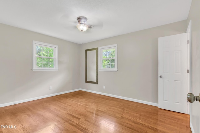 unfurnished room featuring plenty of natural light, light wood-type flooring, and ceiling fan