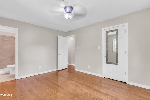 unfurnished bedroom with ceiling fan, ensuite bath, and light hardwood / wood-style floors