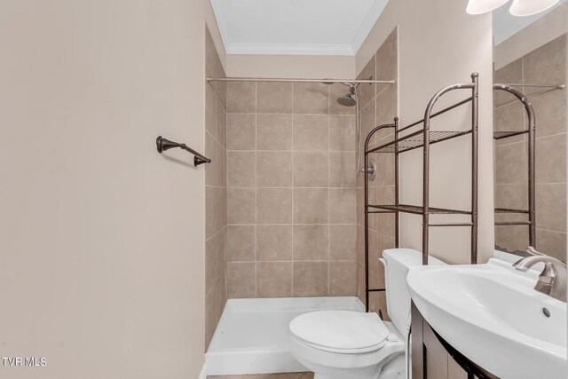 bathroom with tiled shower, ornamental molding, toilet, and large vanity