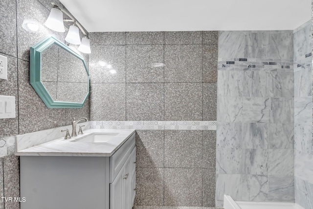 bathroom featuring vanity and tile walls