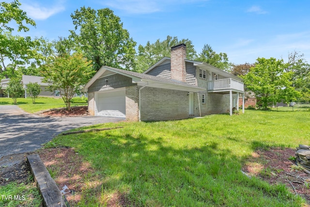 view of side of property featuring a garage, a balcony, and a lawn