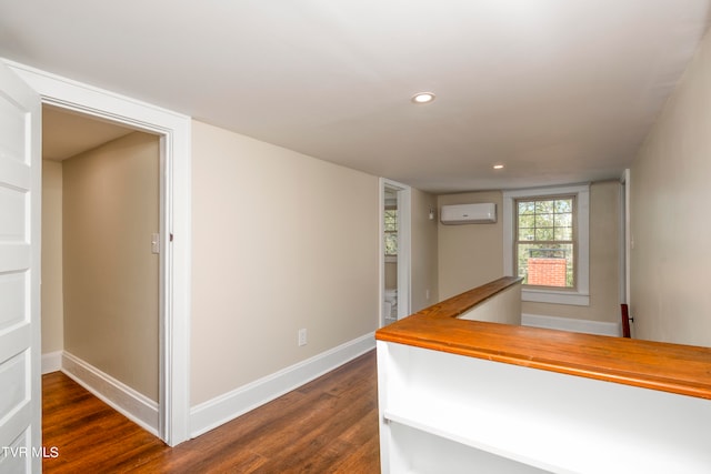 interior space featuring a wall unit AC and dark wood-type flooring