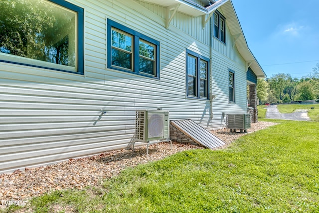 view of home's exterior featuring a yard and central AC unit