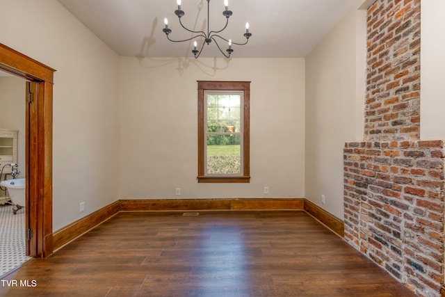 unfurnished room featuring dark hardwood / wood-style flooring and an inviting chandelier