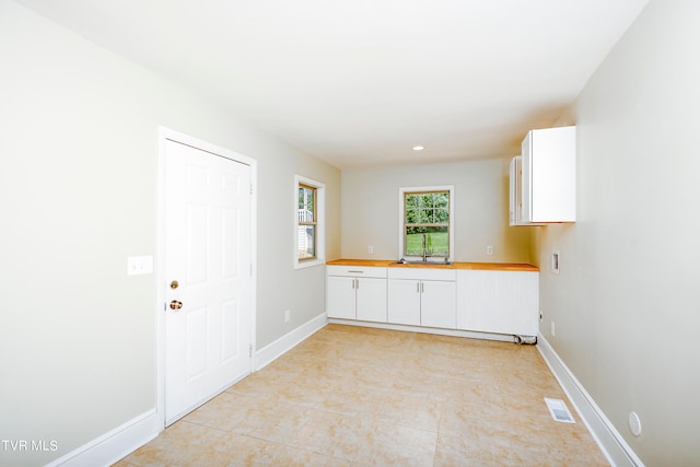 unfurnished room with sink and light tile floors