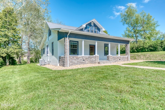 view of front facade with central AC, covered porch, and a front lawn