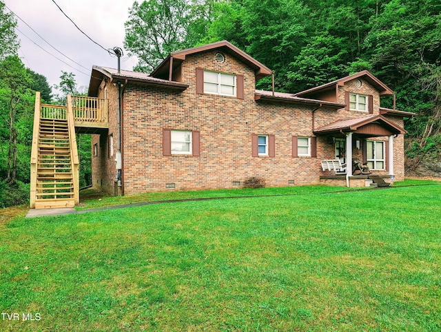 back of house featuring a deck and a lawn