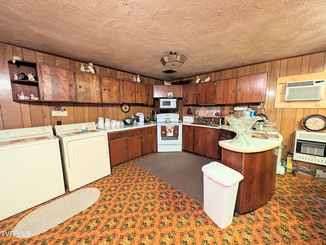 kitchen featuring an AC wall unit, white appliances, kitchen peninsula, independent washer and dryer, and carpet