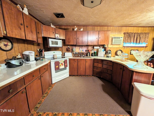 kitchen featuring white appliances, sink, a textured ceiling, carpet flooring, and a wall mounted air conditioner