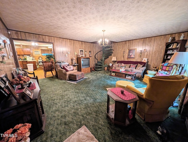 living room with wood walls, carpet, a chandelier, and a textured ceiling