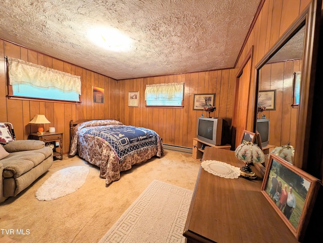 bedroom featuring light carpet, a textured ceiling, a baseboard heating unit, and wooden walls