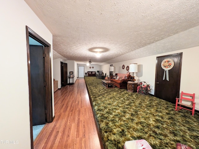 recreation room featuring a textured ceiling and hardwood / wood-style floors