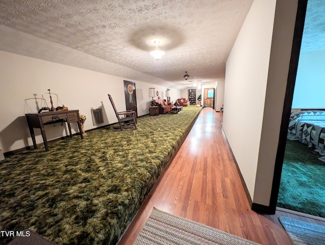 interior space featuring a textured ceiling and hardwood / wood-style floors