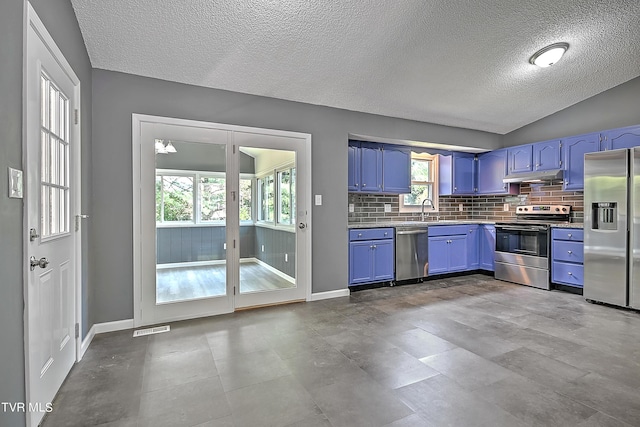 kitchen with blue cabinetry, sink, lofted ceiling, and stainless steel appliances