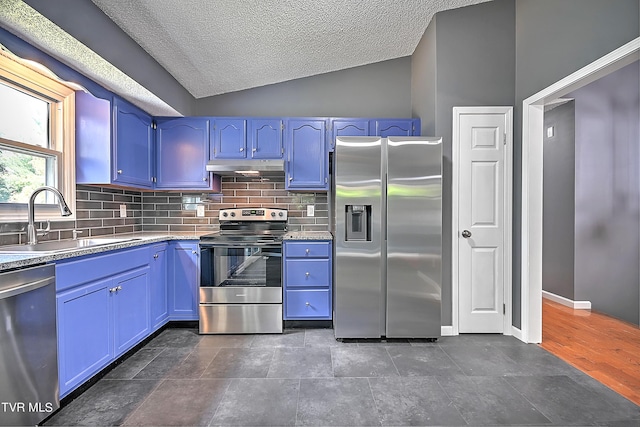 kitchen featuring appliances with stainless steel finishes, tasteful backsplash, vaulted ceiling, blue cabinets, and sink