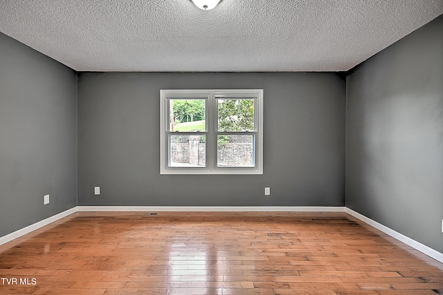 empty room featuring light hardwood / wood-style floors and a textured ceiling