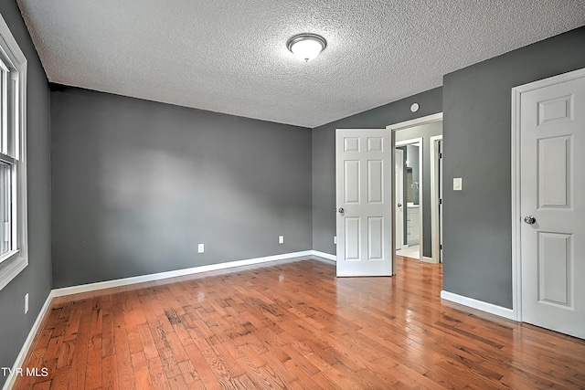 spare room featuring a textured ceiling and hardwood / wood-style flooring