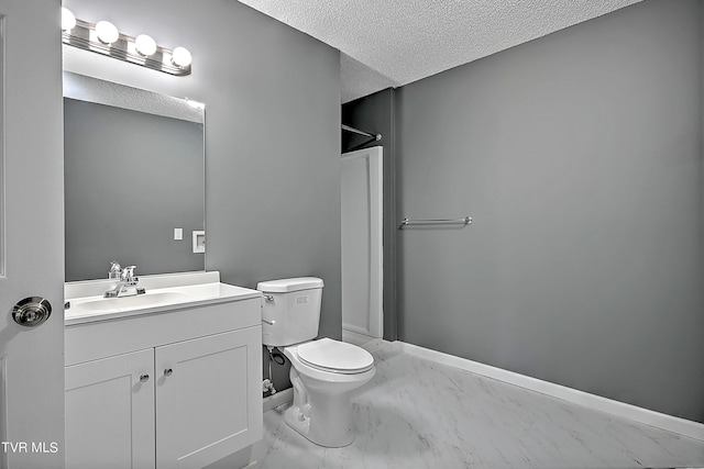 bathroom featuring vanity, toilet, and a textured ceiling