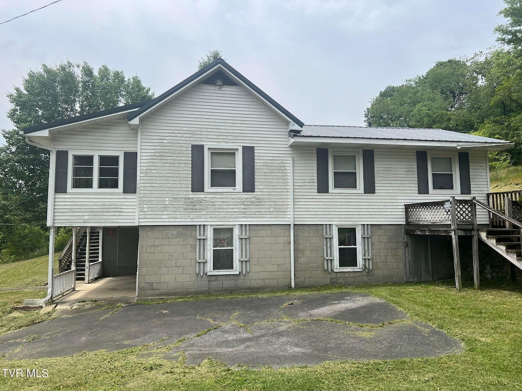 back of property featuring a lawn and a carport